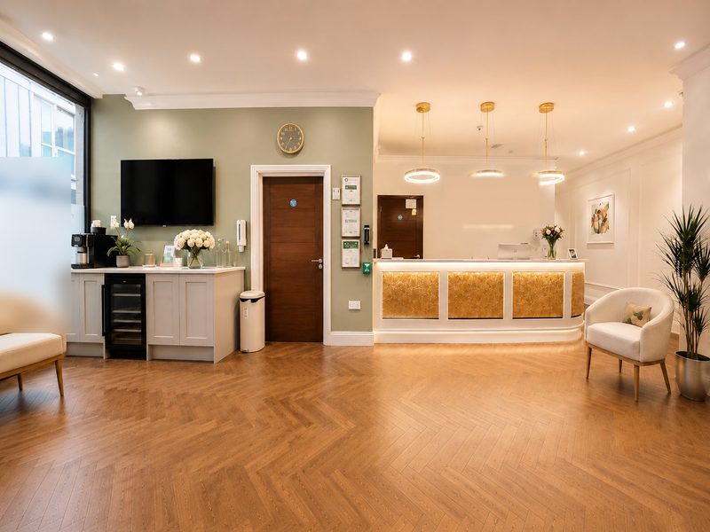 Reception area at Tower Bridge Hospital London Whitechapel — herringbone parquet floor, warm pendant lighting